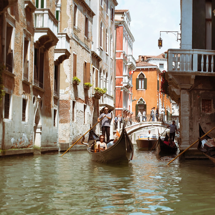 Ein Gondoliere mit Touristen in einem Kanal von Venedig