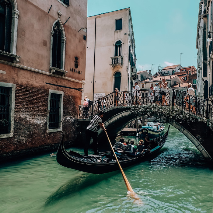 Un gondolier avec des touristes sur un canal de Venise